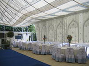 A marquee with tables and blue carpet set up in Sandhurst for a Wedding event